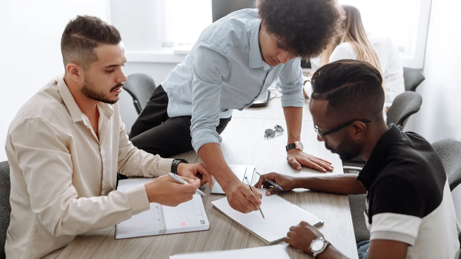 A diverse team of professionals collaborating in a modern office setting, focusing on brainstorming and planning.